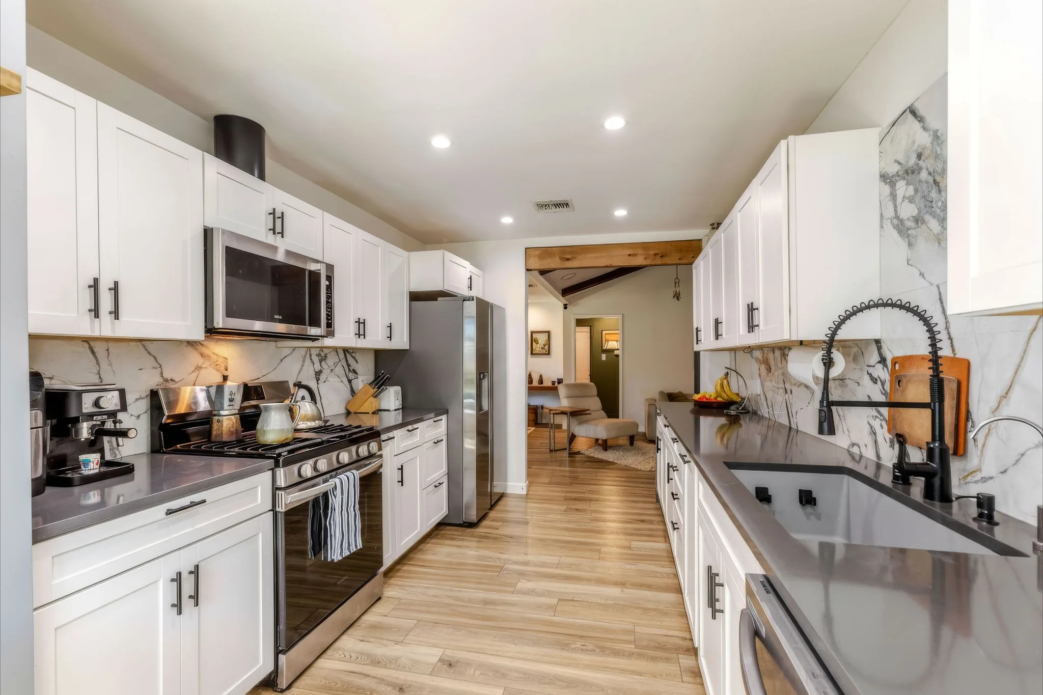 Renovated kitchen with stainless appliances and a marble backsplash