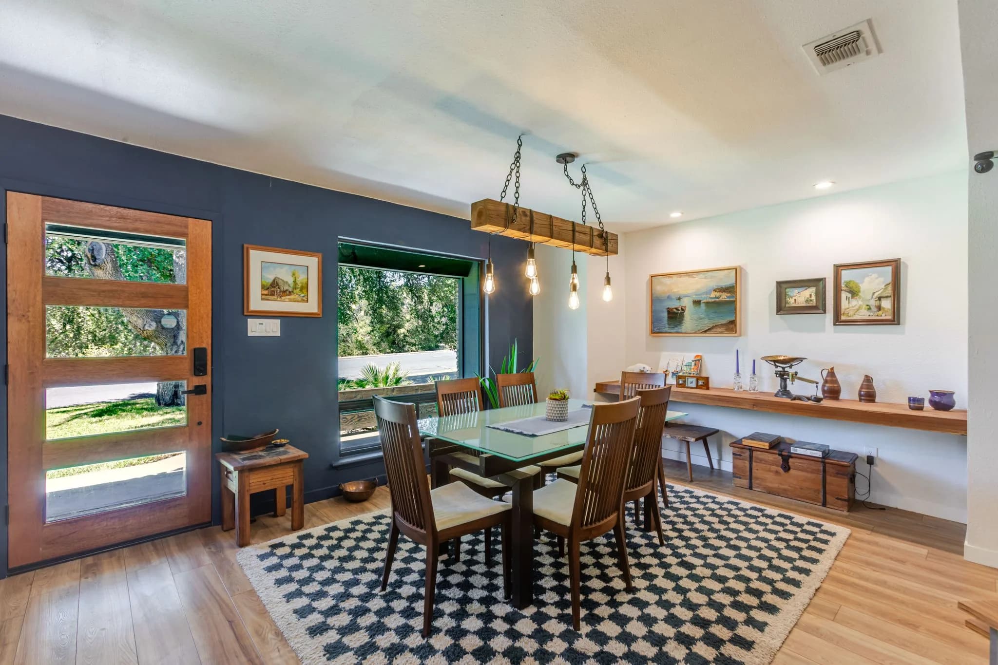 Dining area with a blue accent wall and exposed ceiling beams