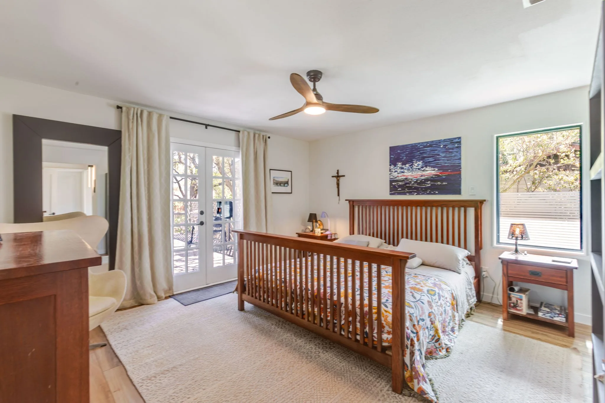 Primary bedroom with a wood bed frame and doors to a patio
