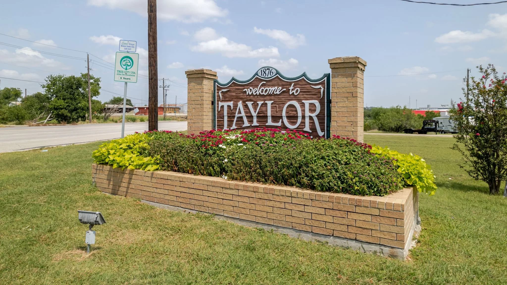 Aerial of a brick Welcome to Taylor monument beside the highway
