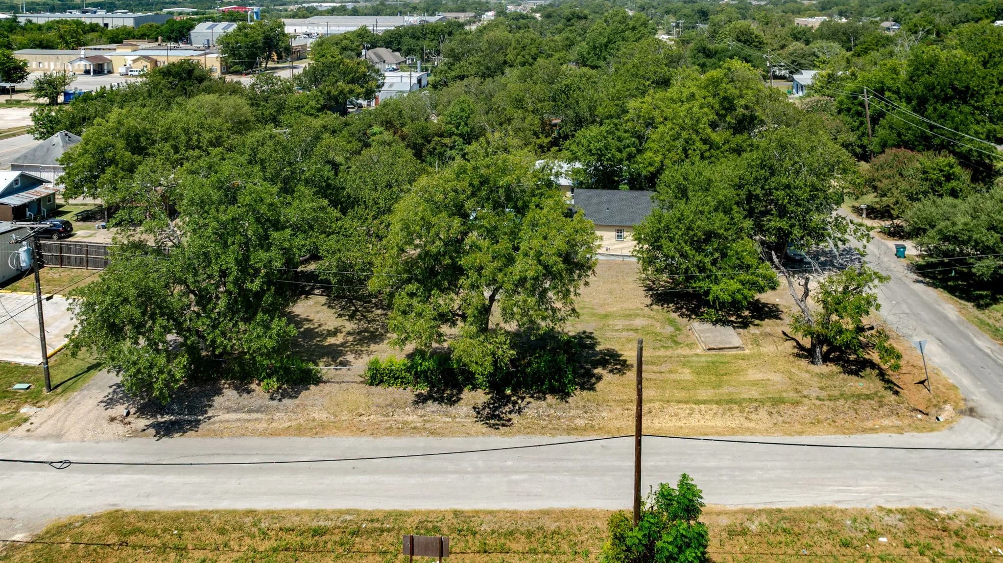 Aerial of a tree lined lot and surrounding neighborhood